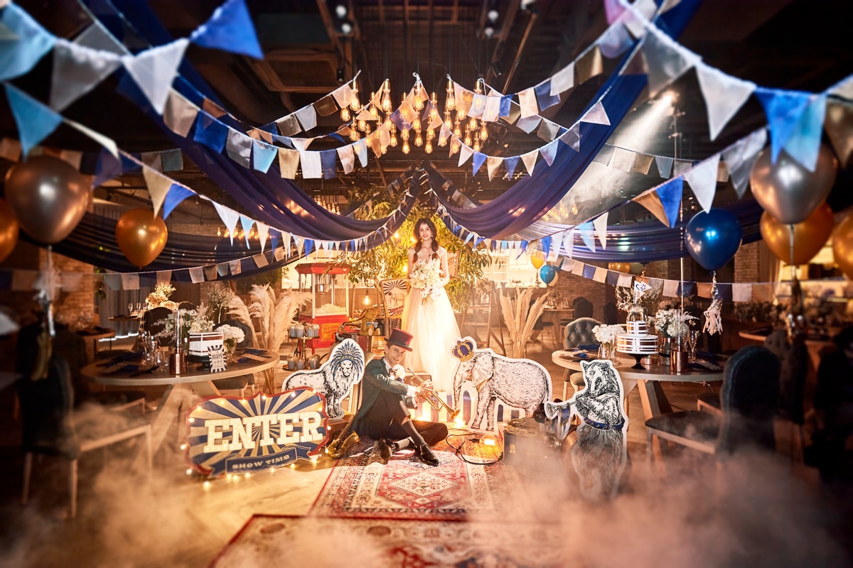 A couple in a theatrical circus-themed reception setting