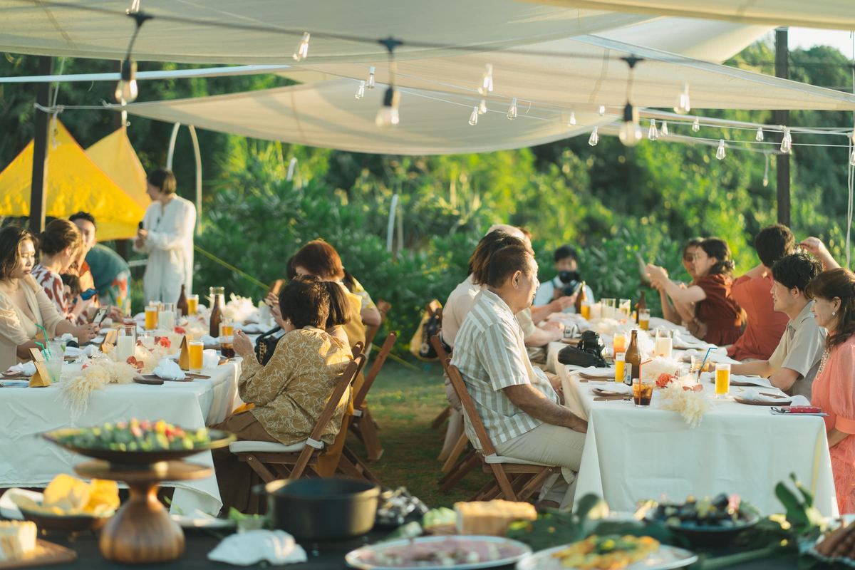 Guests dining beneath a canopy at an outdoor reception
