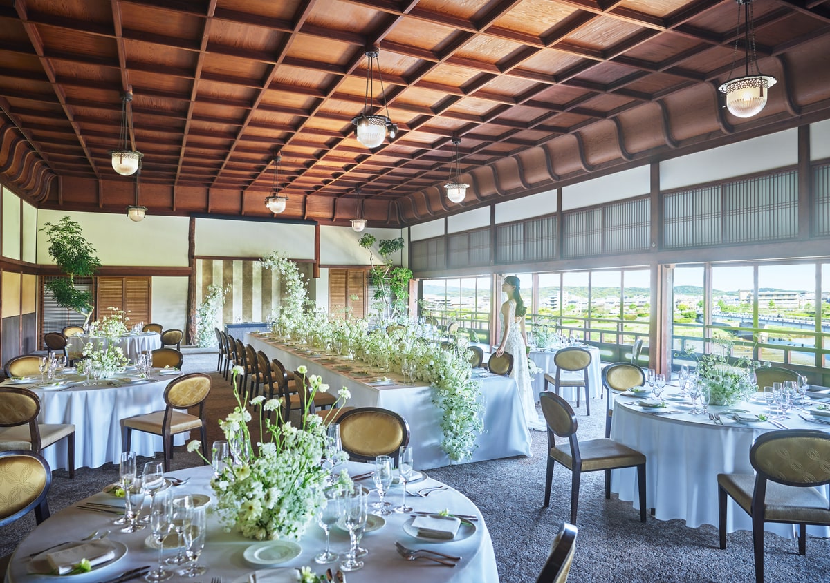 A river-facing reception room with round tables