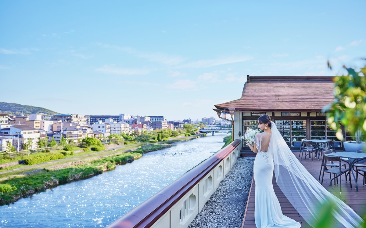 A bride standing on a terrace overlooking the Kamogawa