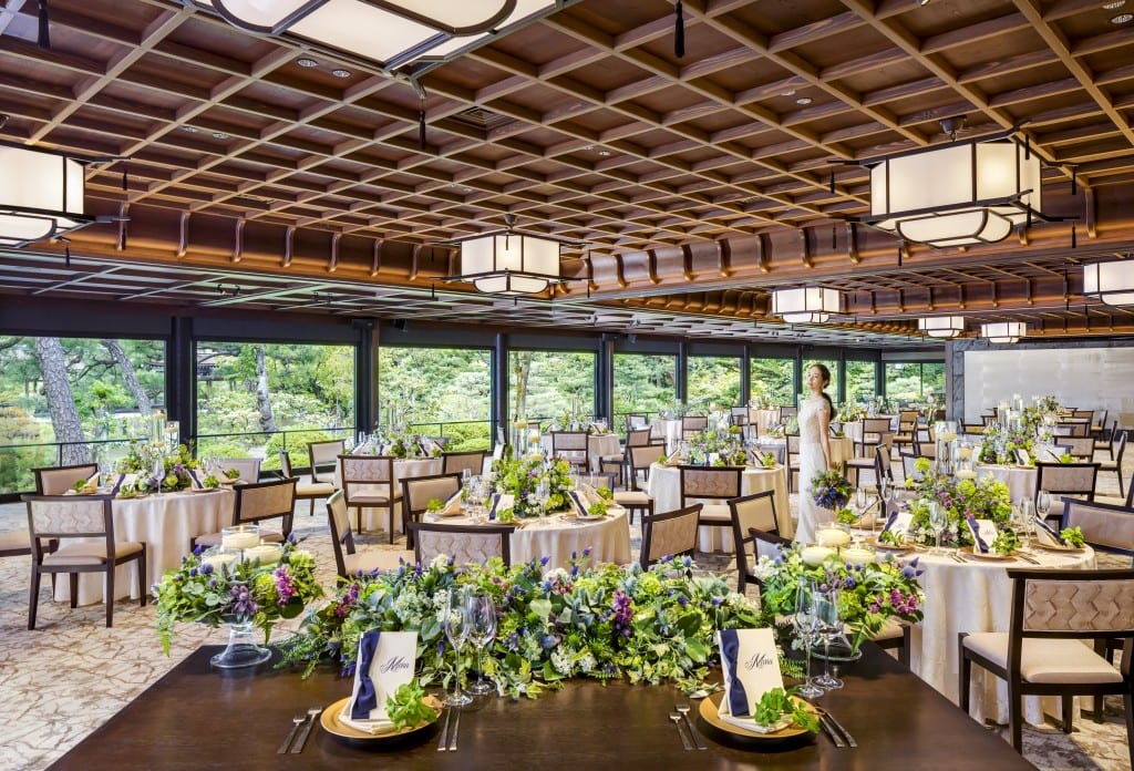 A garden-facing banquet hall with a coffered wood ceiling
