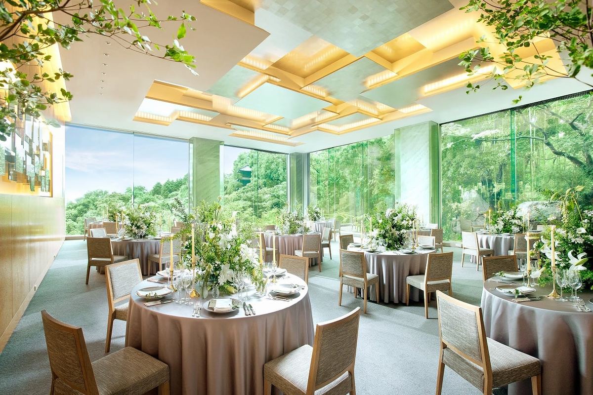 A reception room set with round tables and views of the garden