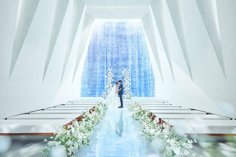 A couple at the altar of the white chapel at KOTOWA Kyoto Yasaka