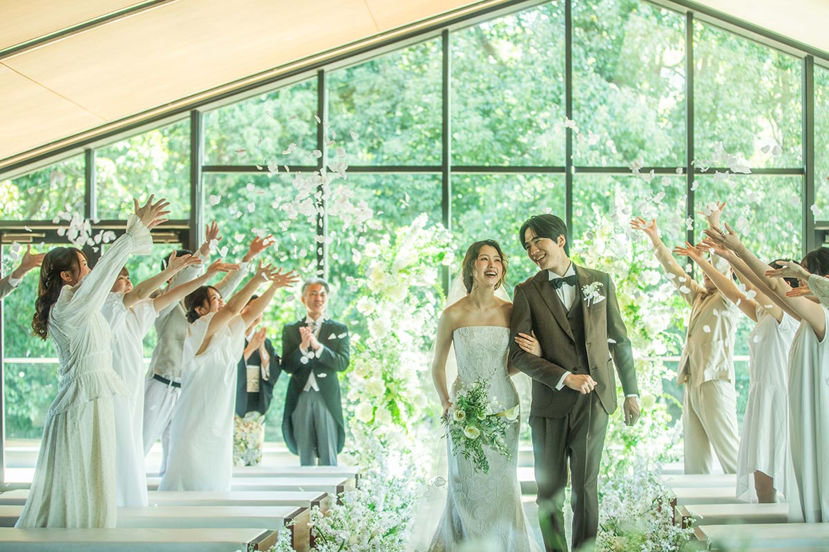 A couple standing in the white chapel with its blue waterfall backdrop