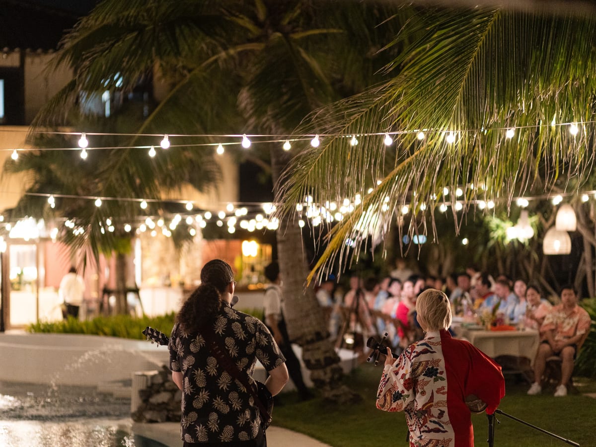 Musicians performing for guests in the illuminated garden