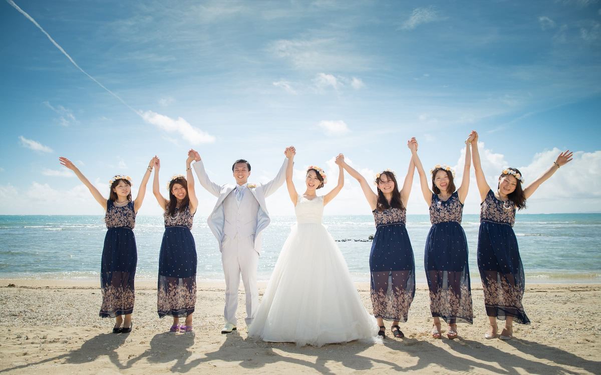 The couple and wedding party celebrating on the beach