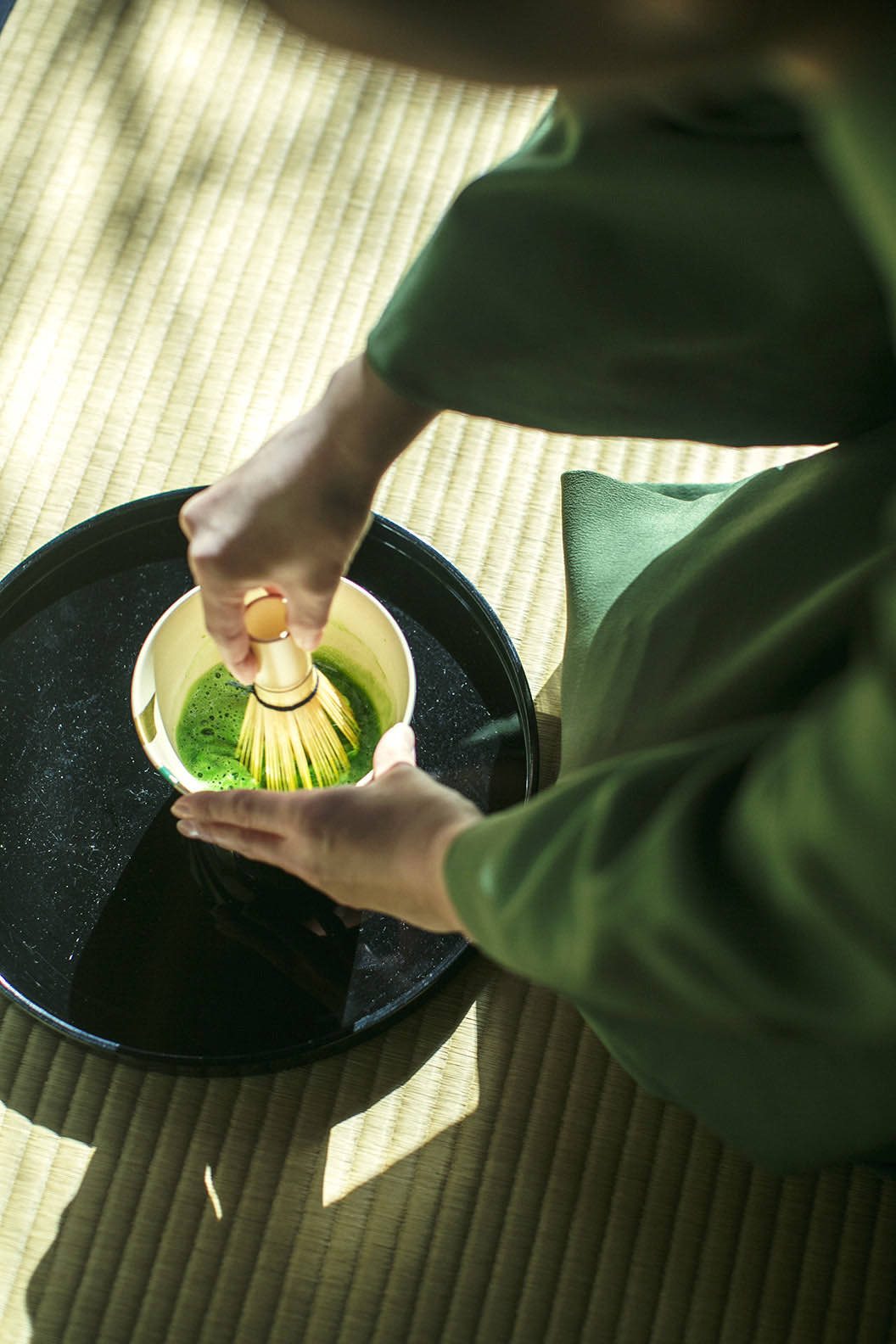 Matcha being prepared in a sunlit tatami room