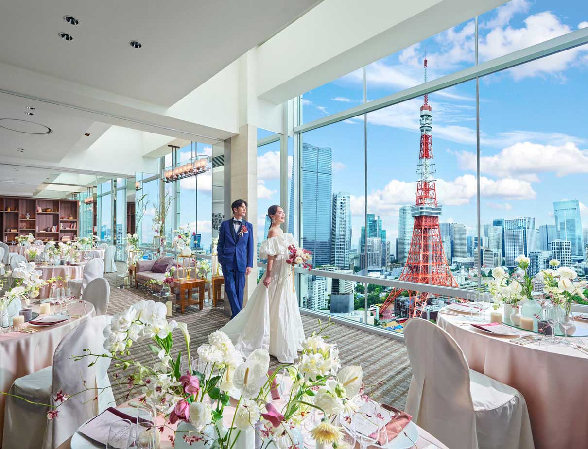 A couple in the Sky Banquet with Tokyo Tower visible through the windows