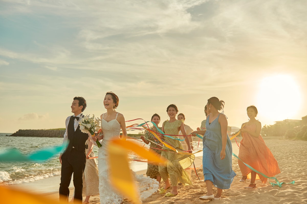 The couple and guests celebrating on the beach at sunset